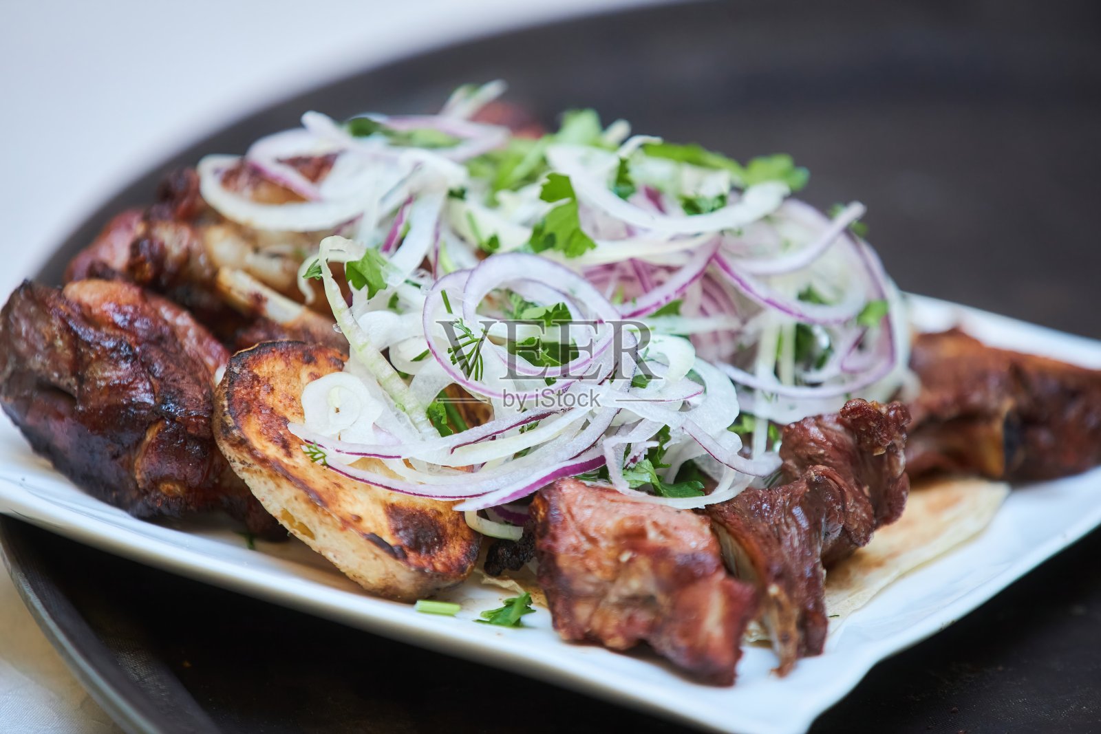 美味的烤肉摆在节日的餐桌上。餐馆里的荤菜。照片摄影图片