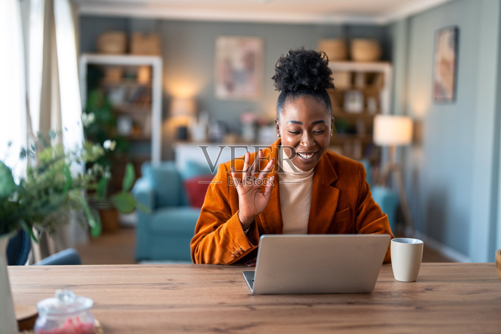 年轻的女商人在虚拟视频电话会议中挥手看着笔记本电脑照片摄影图片