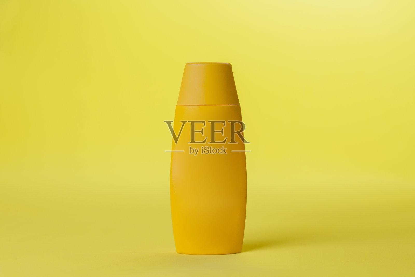 黄色防晒霜瓶在彩色背景照片摄影图片