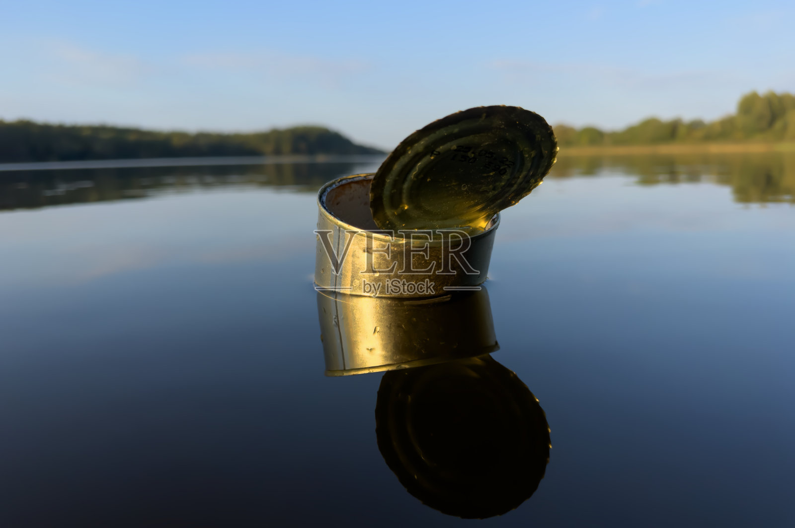 锡在湖水中会被浪费。空金属锡罐垃圾和海洋中的食物垃圾。照片摄影图片