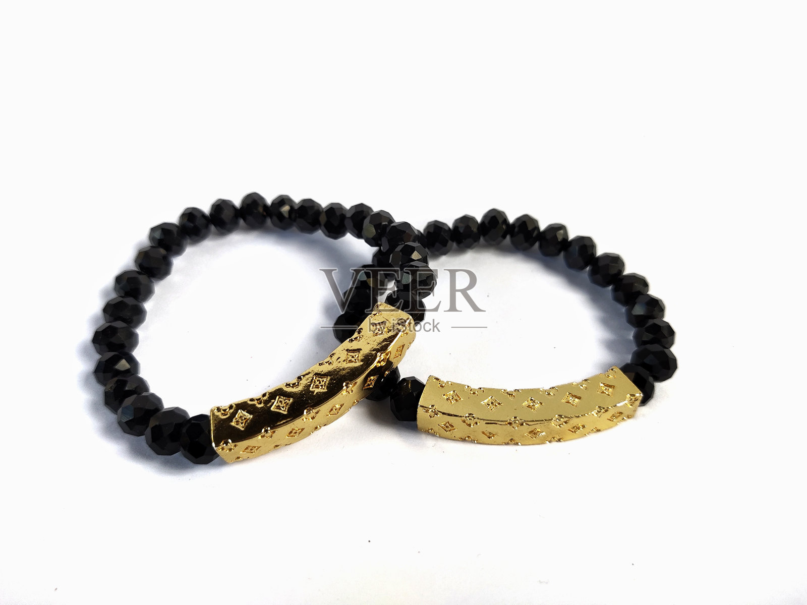 照片中的黑色手镯有金色装饰照片摄影图片