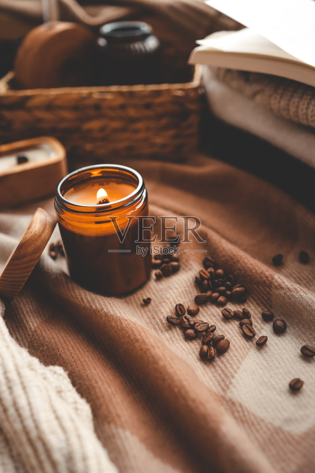 一支燃烧着的蜡烛散发着咖啡的香味，一本打开的书和一叠舒适的毛衣，一幅美丽的画面照片摄影图片