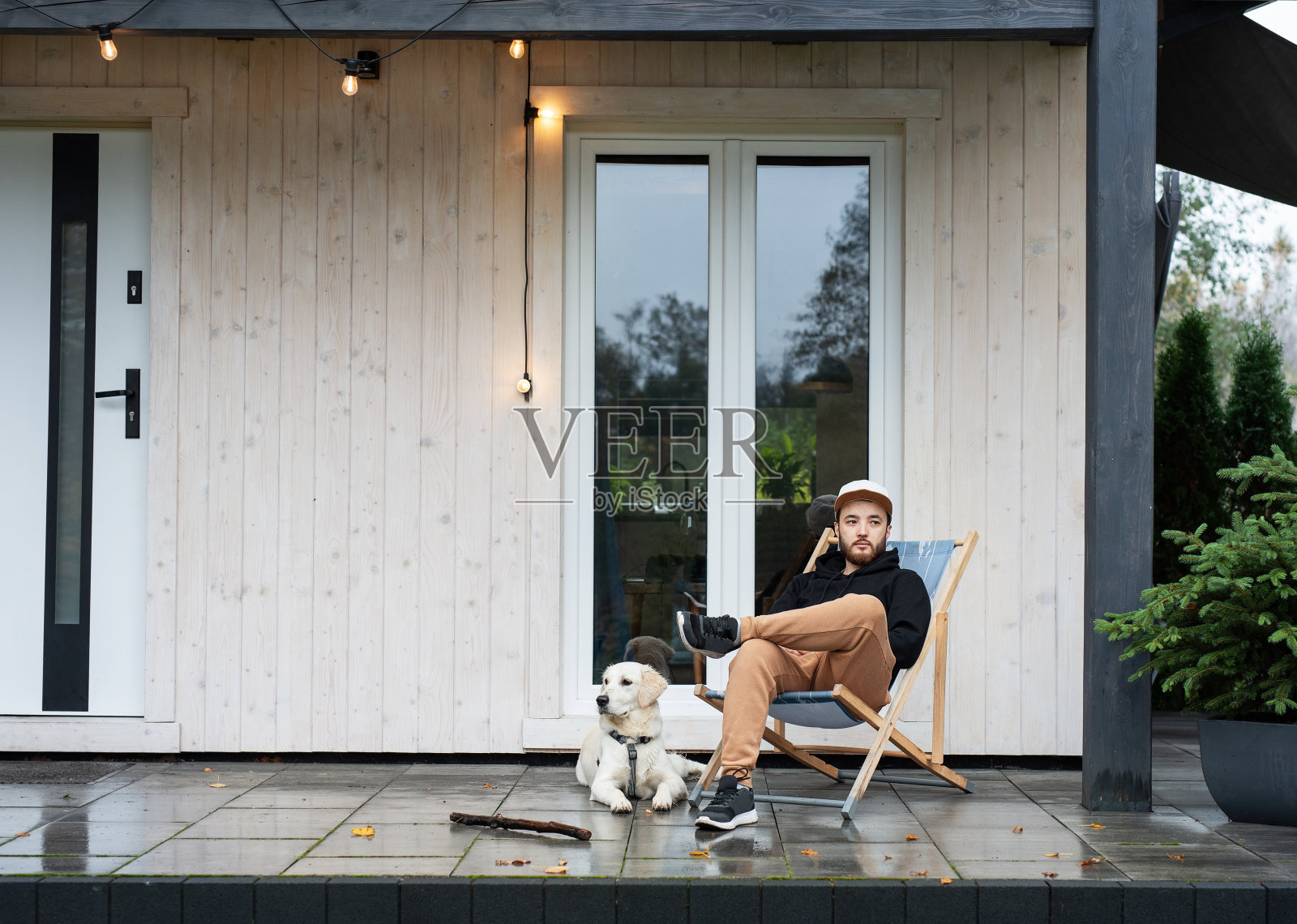 一个年轻人带着狗坐在阳台上照片摄影图片