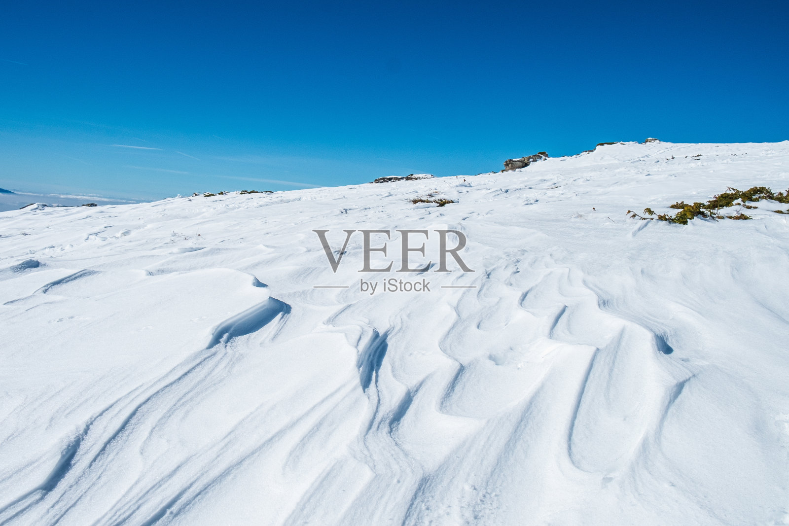 高原上覆盖着雪山沙丘，在蓝天下照片摄影图片