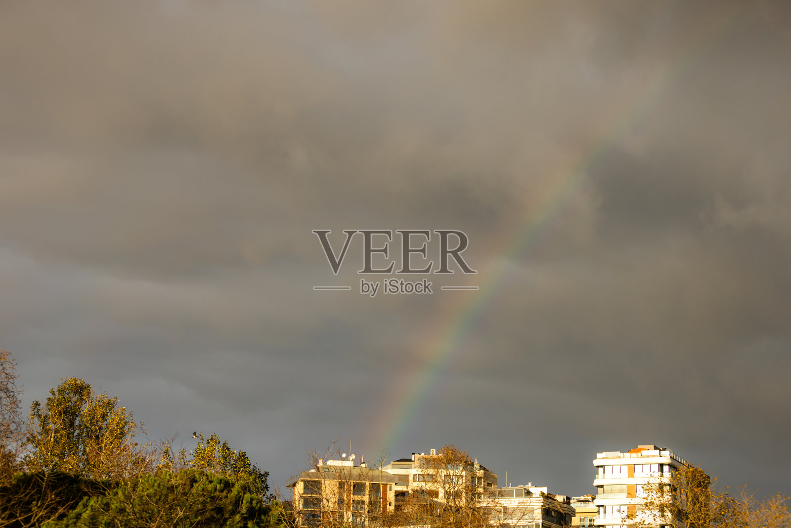 城市景观上的彩虹。照片摄影图片