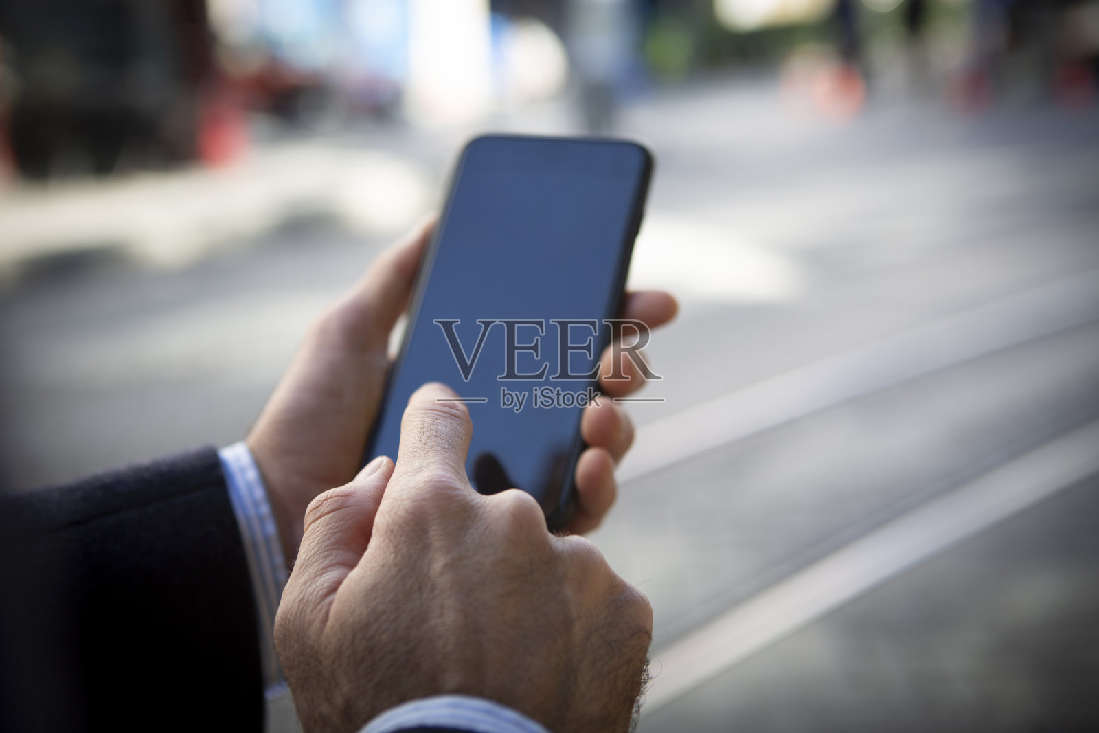 一个无法辨认的商人在街上使用手机的手照片摄影图片