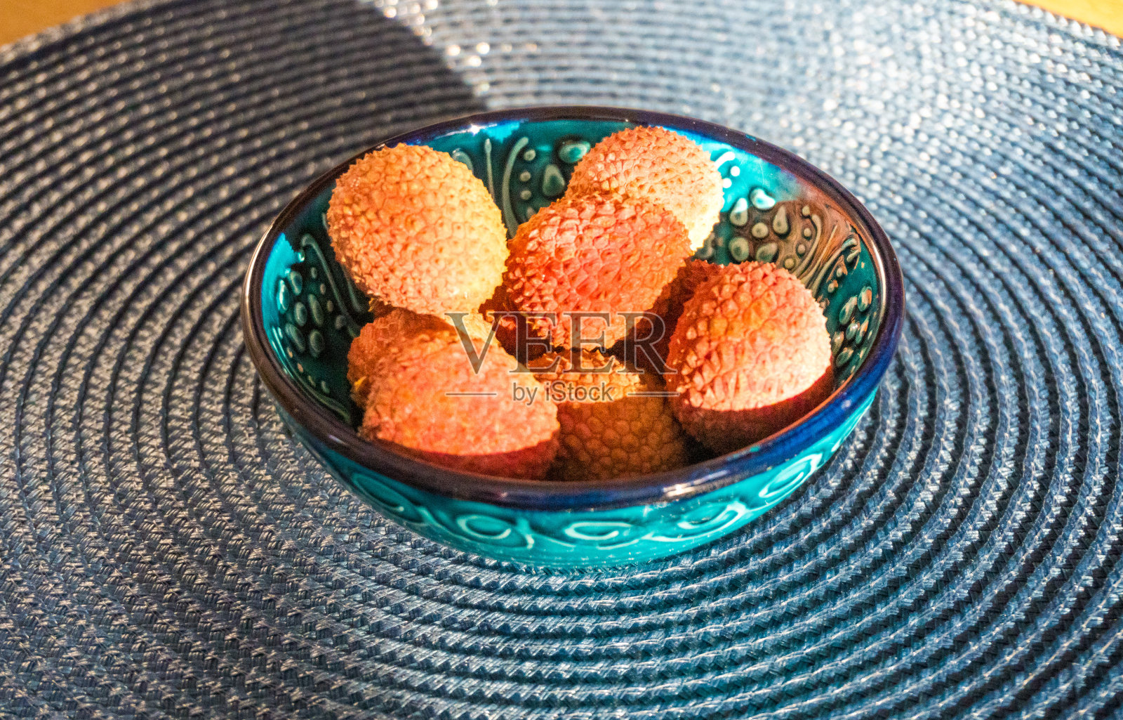 蓝色盘子背景上的荔枝果，从荔枝树上剥下来的新鲜成熟的荔枝照片摄影图片