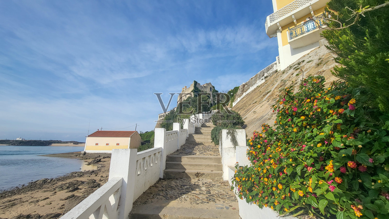 在晴朗的日子里，蔚蓝的天空，小船在米拉河上俯瞰中世纪的圣克莱门特堡。villa Nova De Milfontes，葡萄牙，罗塔维森蒂纳海岸。渔夫小径照片摄影图片