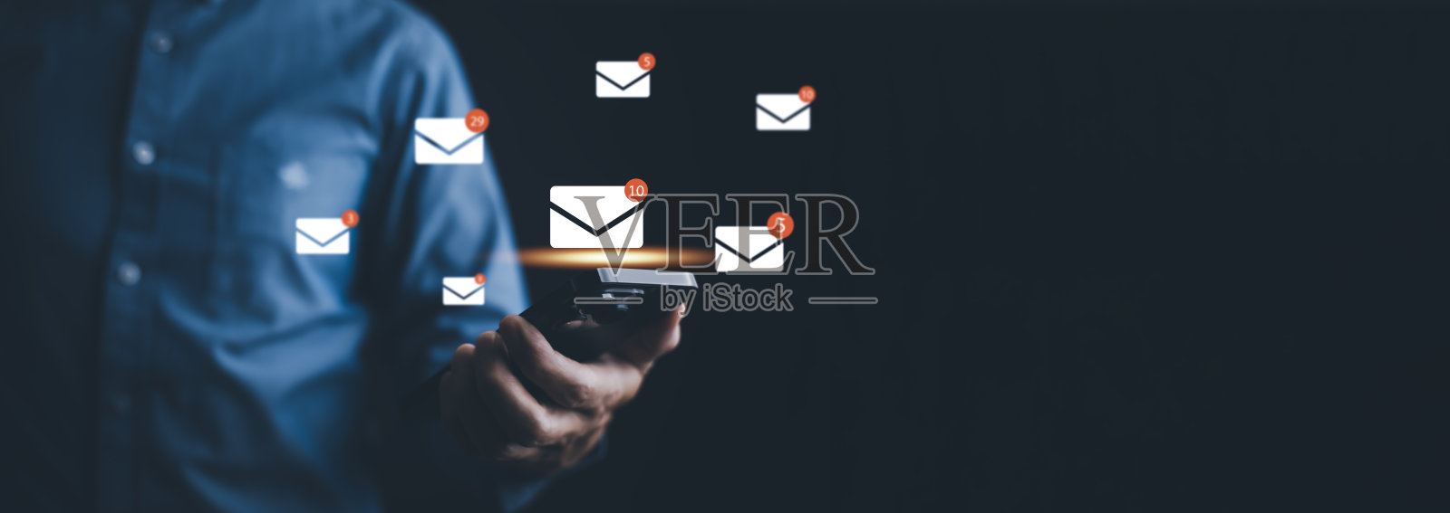 商人手按智能手机发送电子邮件从笔记本电脑，电子邮件和短信营销的概念。企业直销方案。邮寄客户名单。照片摄影图片