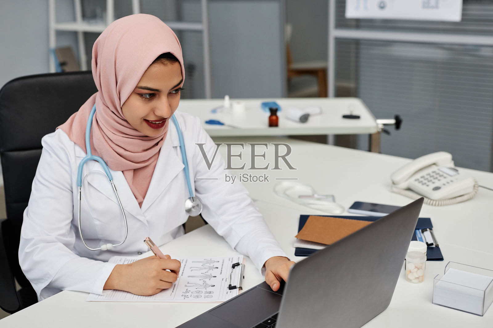 穆斯林女全科医生填写病人卡照片摄影图片