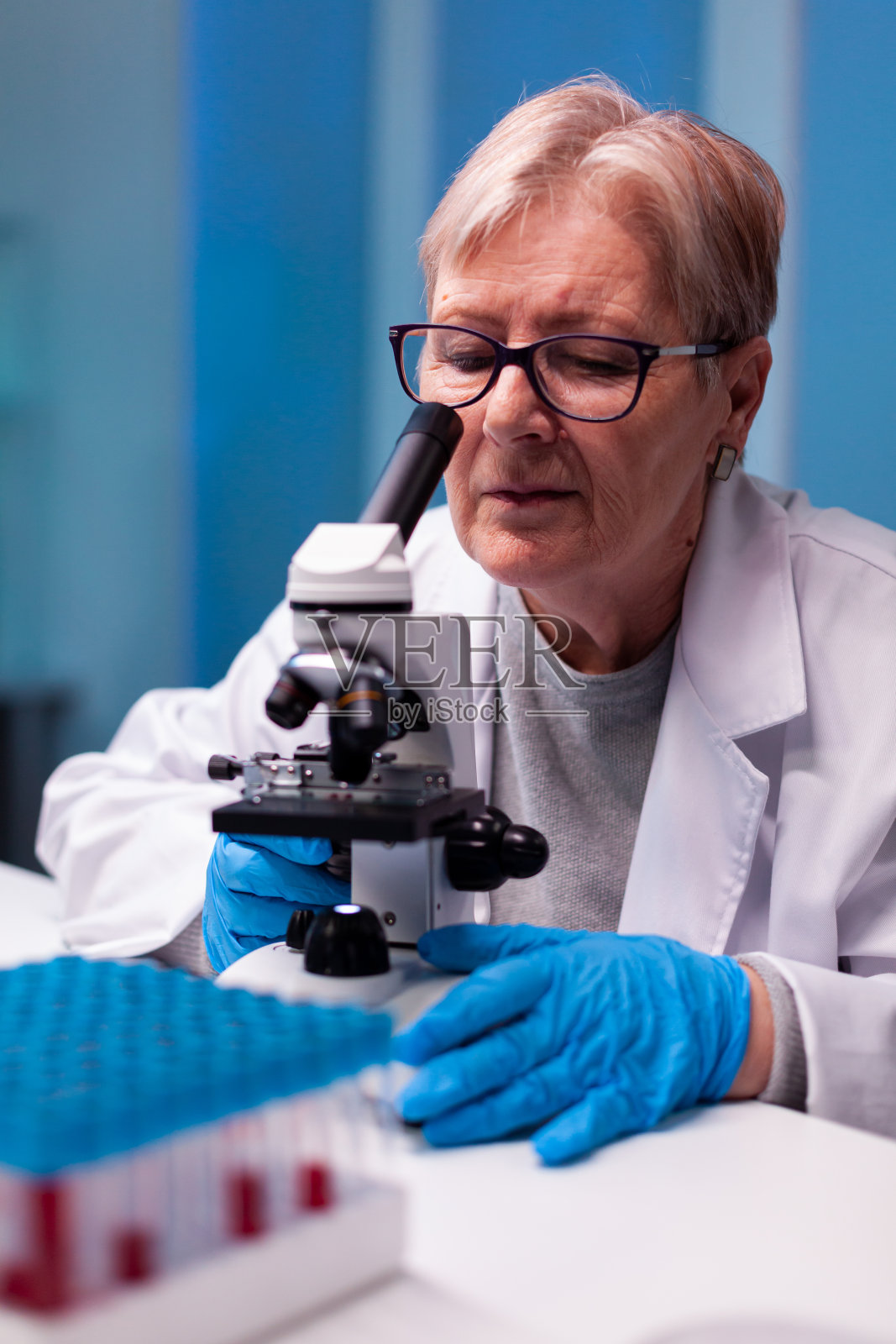 资深科学家在生物实验室通过显微镜观察样品照片摄影图片