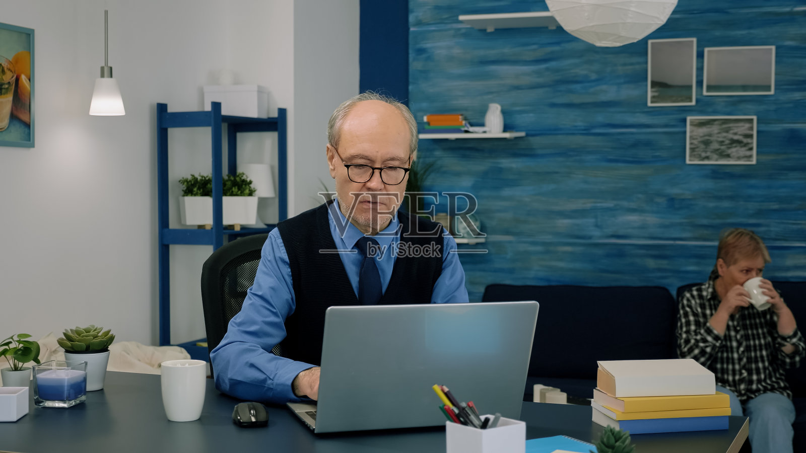 退休项目经理在家工作，打开笔记本电脑看新闻照片摄影图片