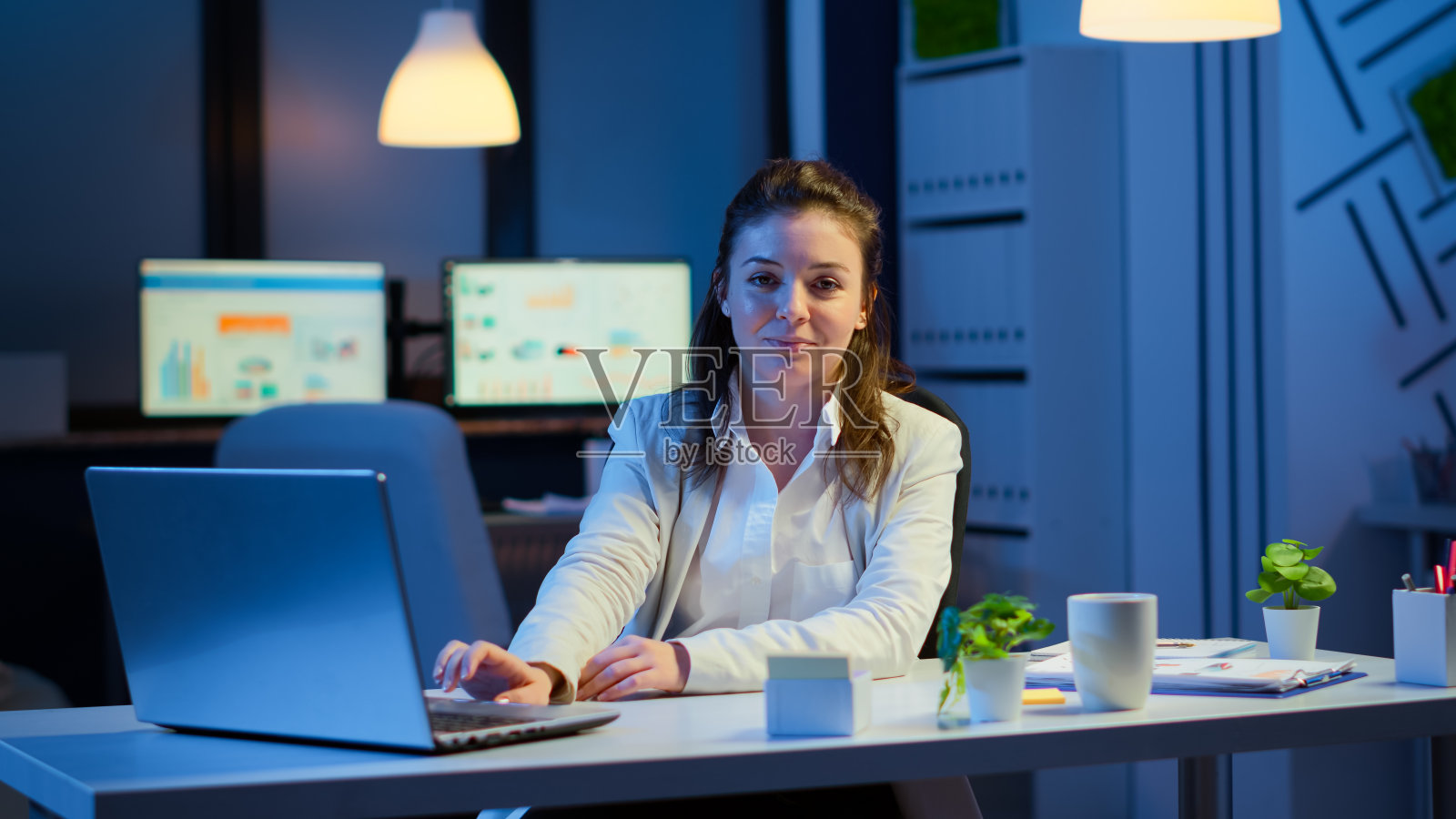 女商人在笔记本电脑上打字后微笑着看着镜头照片摄影图片