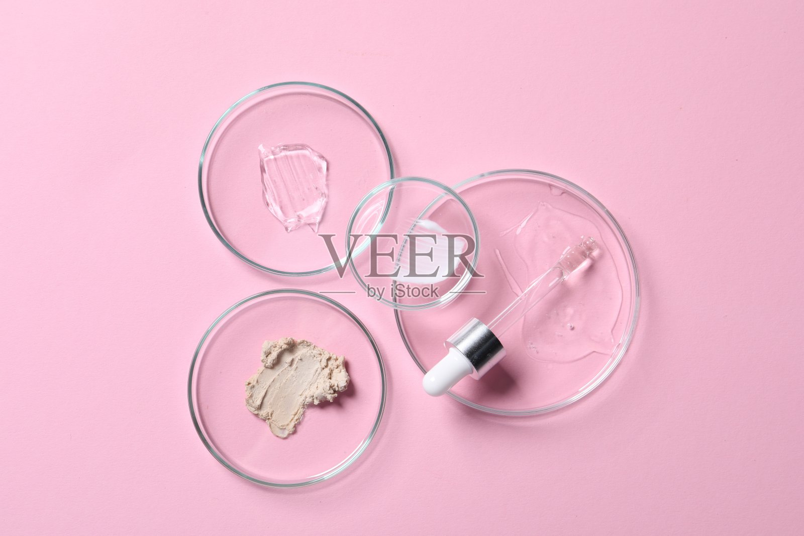 移液器，化妆品血清和粉红色背景样品的培养皿，平放置照片摄影图片
