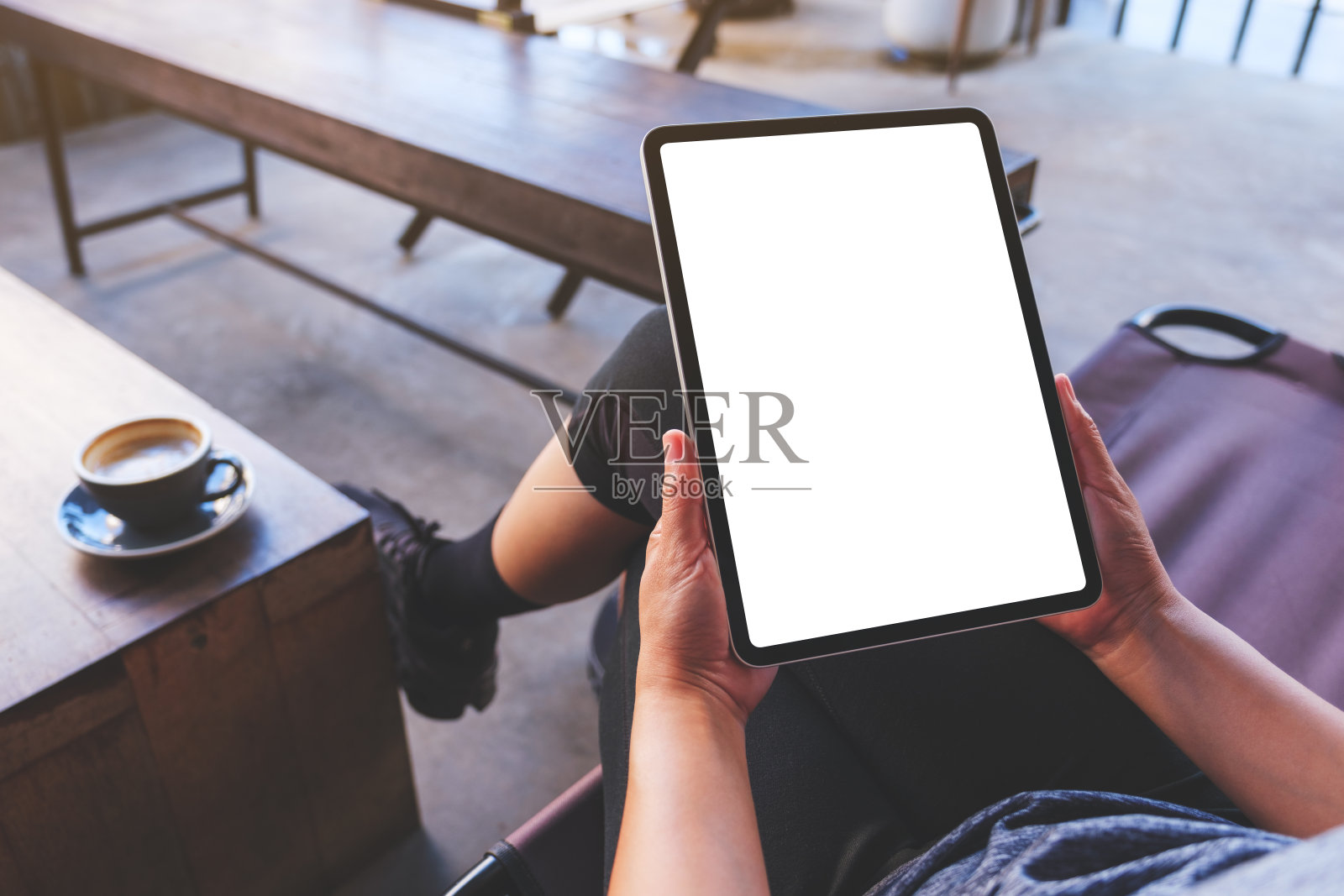 咖啡厅里，一个女人拿着数字平板电脑，屏幕是空白的照片摄影图片