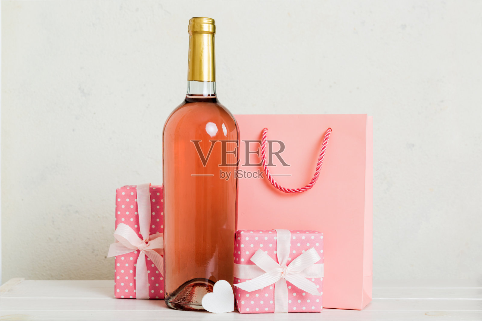 一瓶酒在彩色背景情人节与礼盒。带有当前框透视图的心形，带有复制空间照片摄影图片
