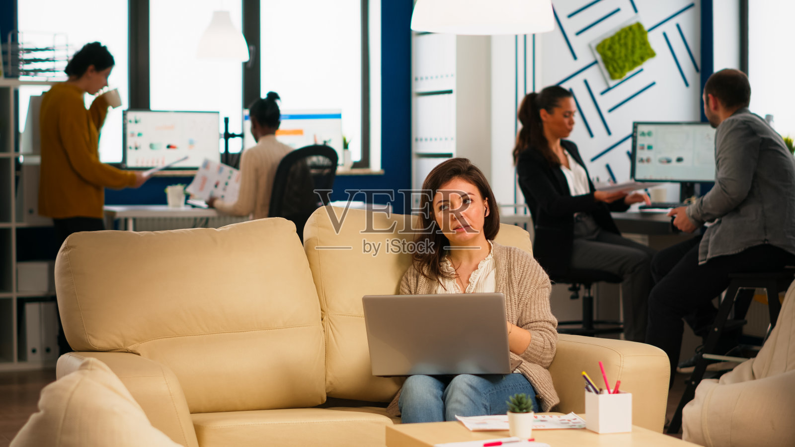 女经理坐在沙发上拿着笔记本电脑进行视频通话照片摄影图片