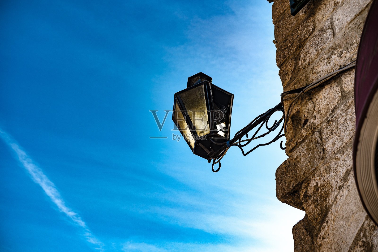 街灯古风上石墙楼，蓝天为背景照片摄影图片