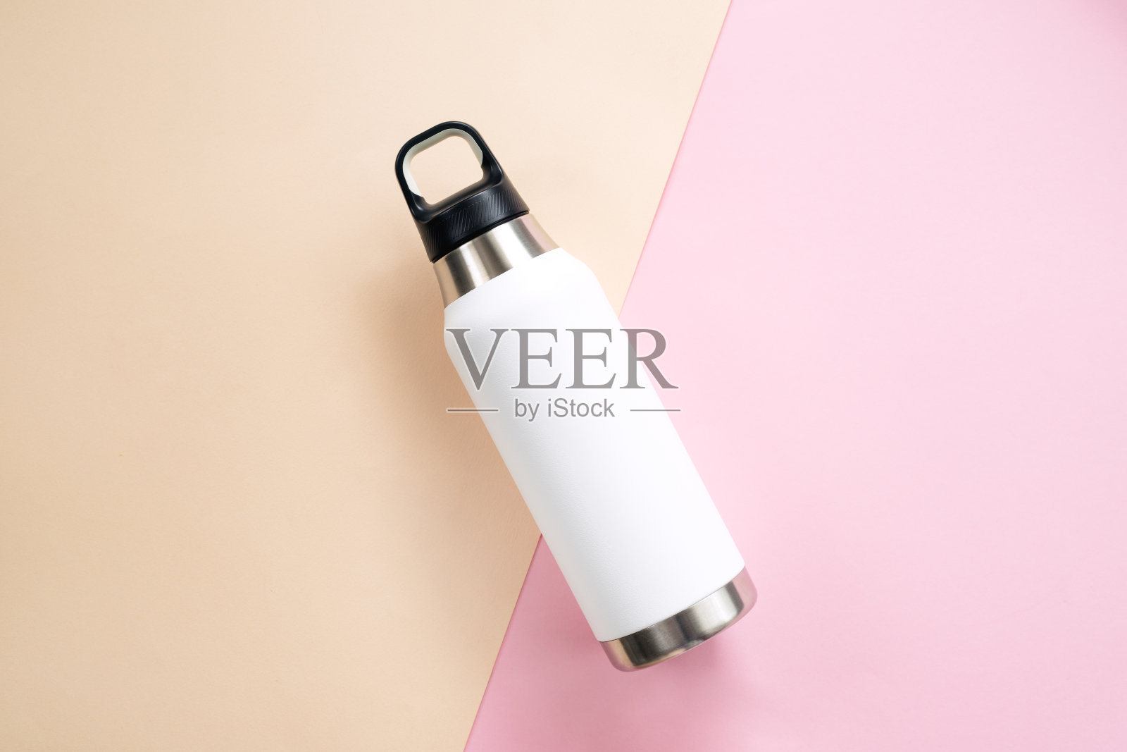 桌子上可重复使用的环保钢热水瓶。照片摄影图片