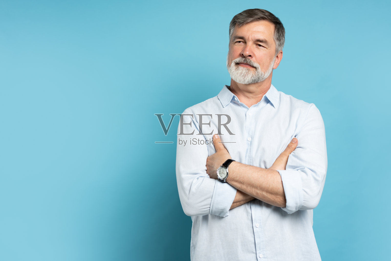 一个快乐随意的老人的肖像，微笑着，中年，白发的成熟男性，孤立在蓝色的背景上照片摄影图片