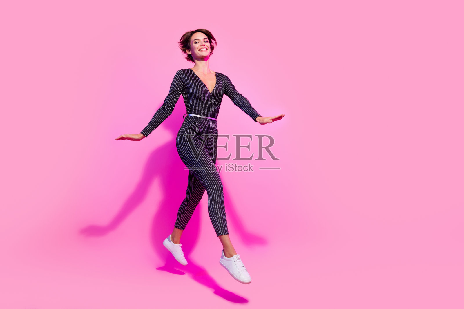 全身照片迷人甜美的女孩穿着魅力整体走跳高空空间孤立的粉红色背景照片摄影图片