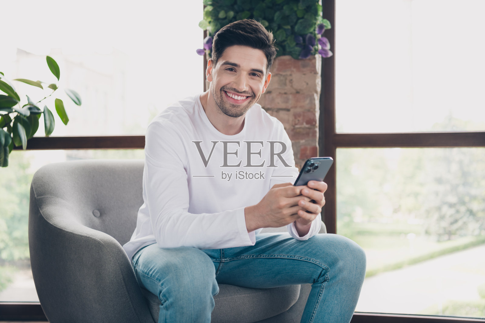 时髦快乐的年轻人穿着白色衬衫，在公寓房间里交流现代小工具的照片照片摄影图片