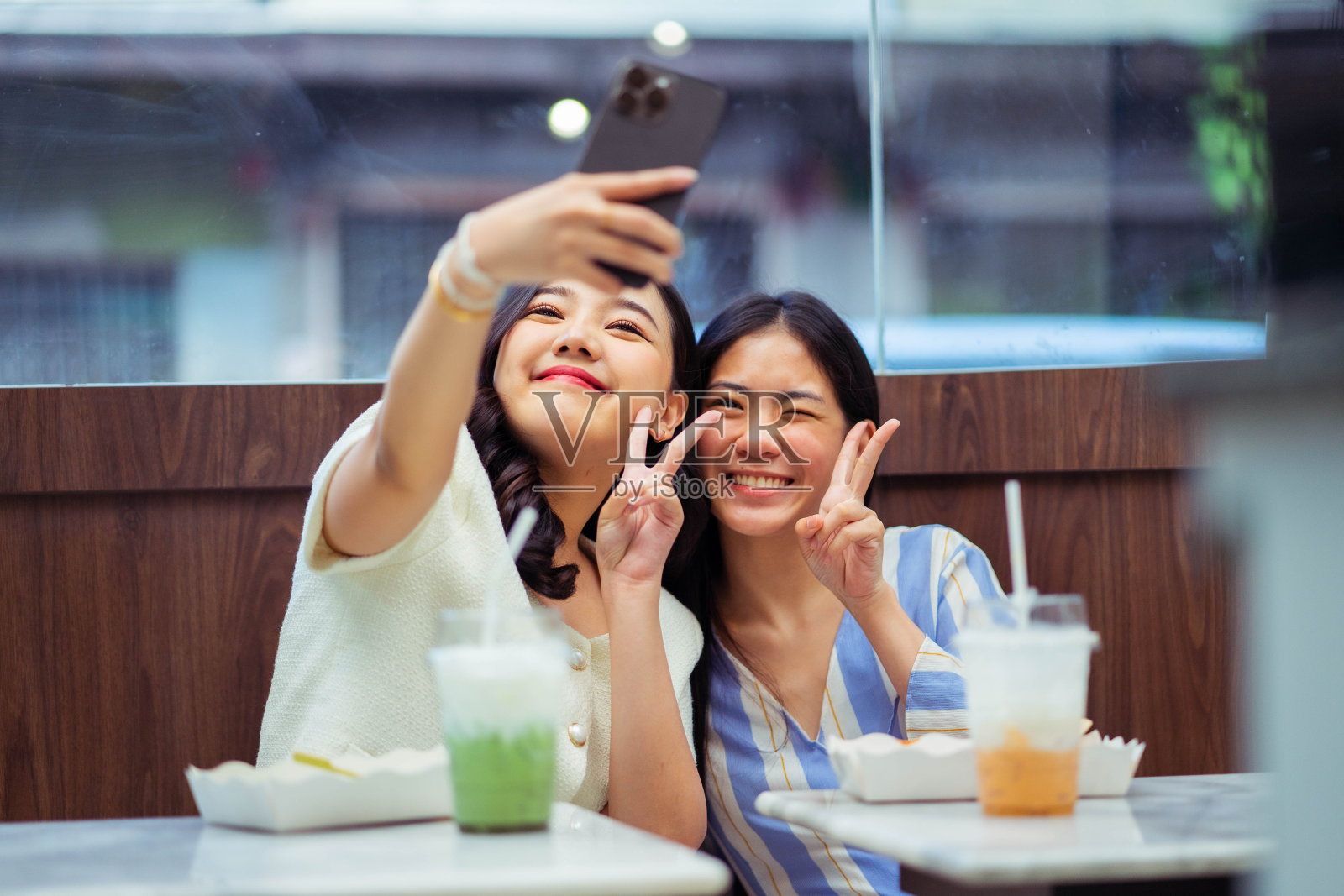 两个女人在咖啡馆自拍。沟通和友谊的概念。照片摄影图片