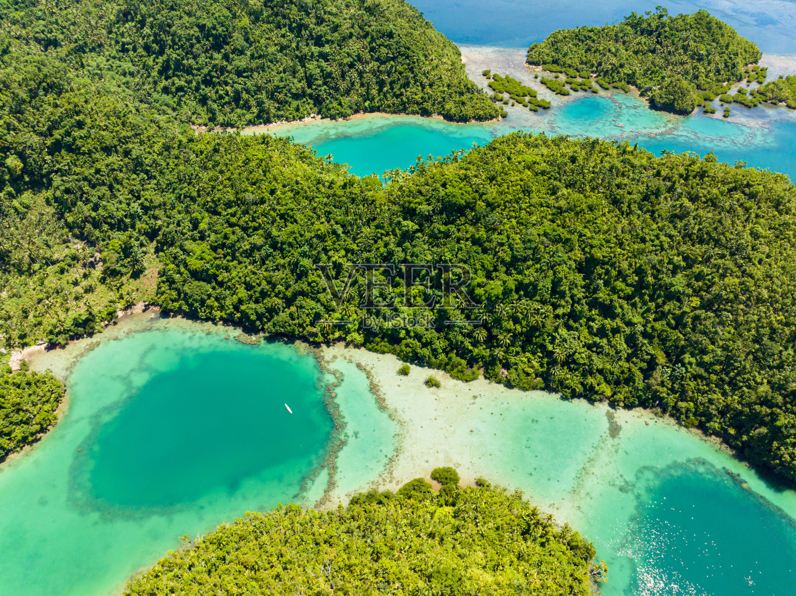飞越热带小岛和山脉。照片摄影图片