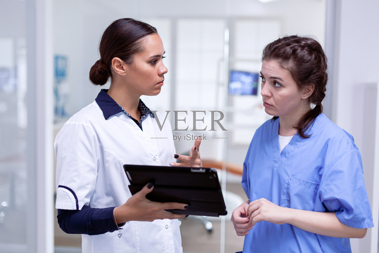 牙医看着护士解释牙齿感染照片摄影图片