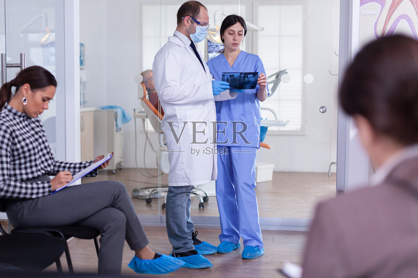 牙科医生在口腔等候区给病人拍x光片照片摄影图片