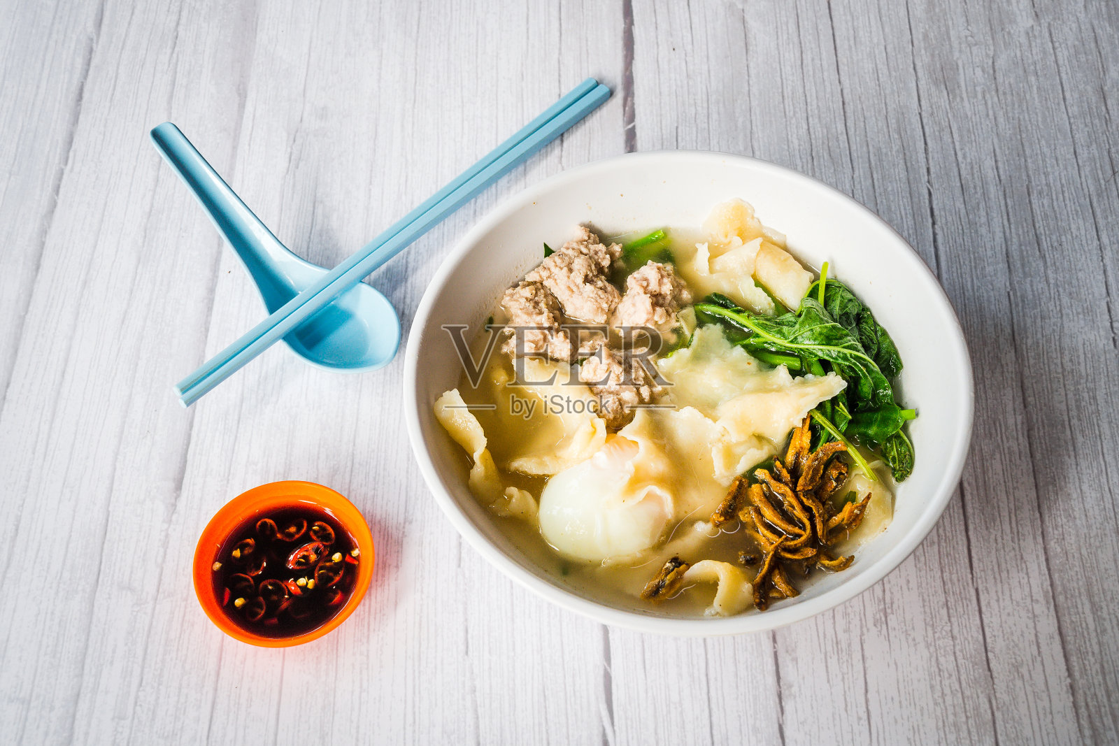 中国面食用面粉片和肉末、鸡蛋、炸凤尾鱼、菠菜一起泡在汤里照片摄影图片