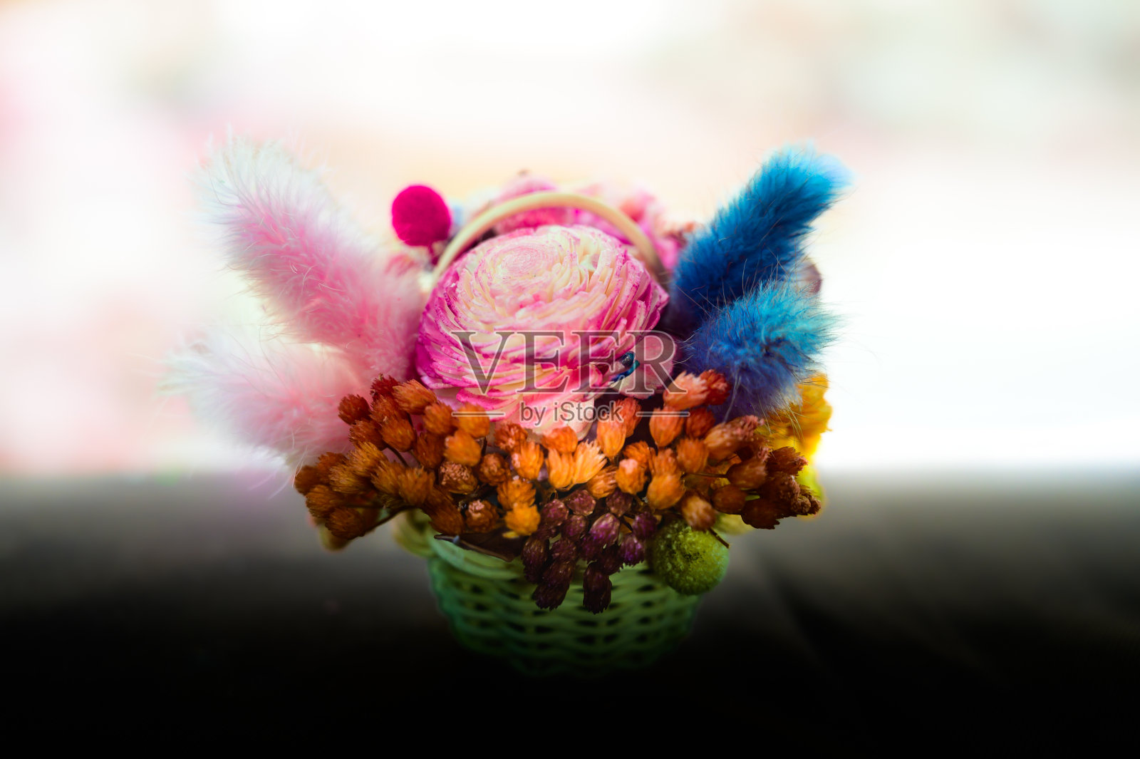 把色彩鲜艳的干花放在小柳条篮子里照片摄影图片