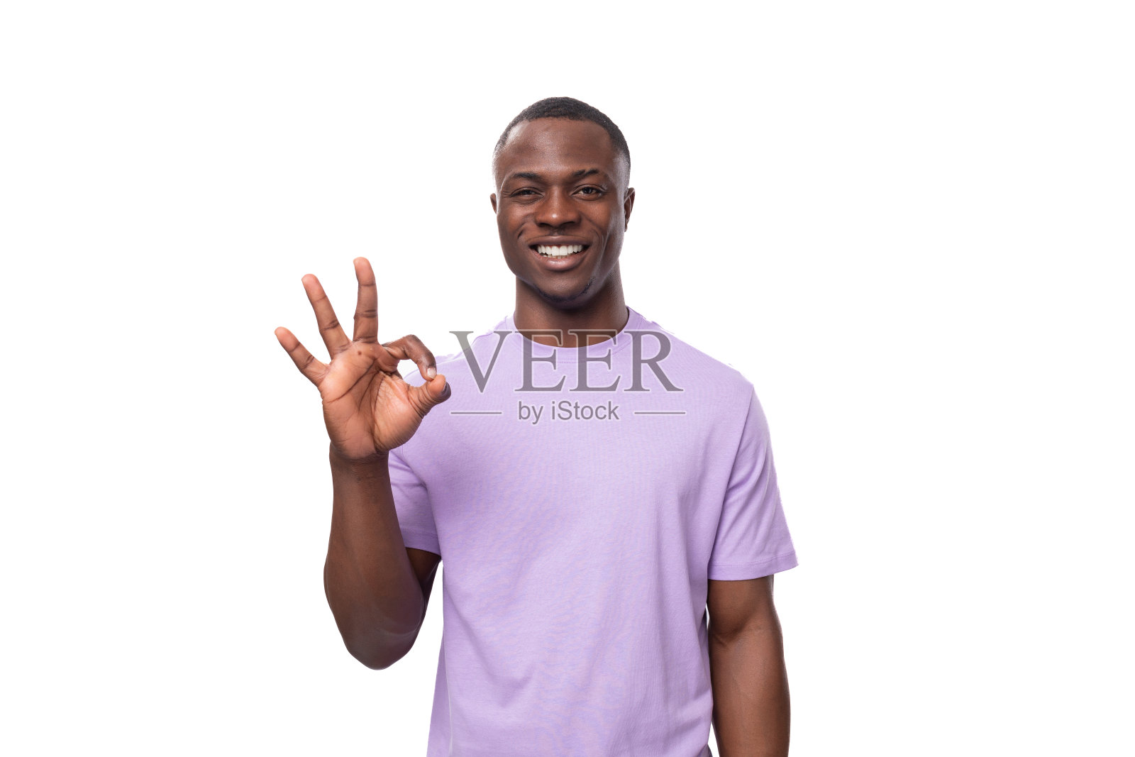 一个穿着淡紫色t恤的乐观的美国年轻人在白色背景上微笑照片摄影图片