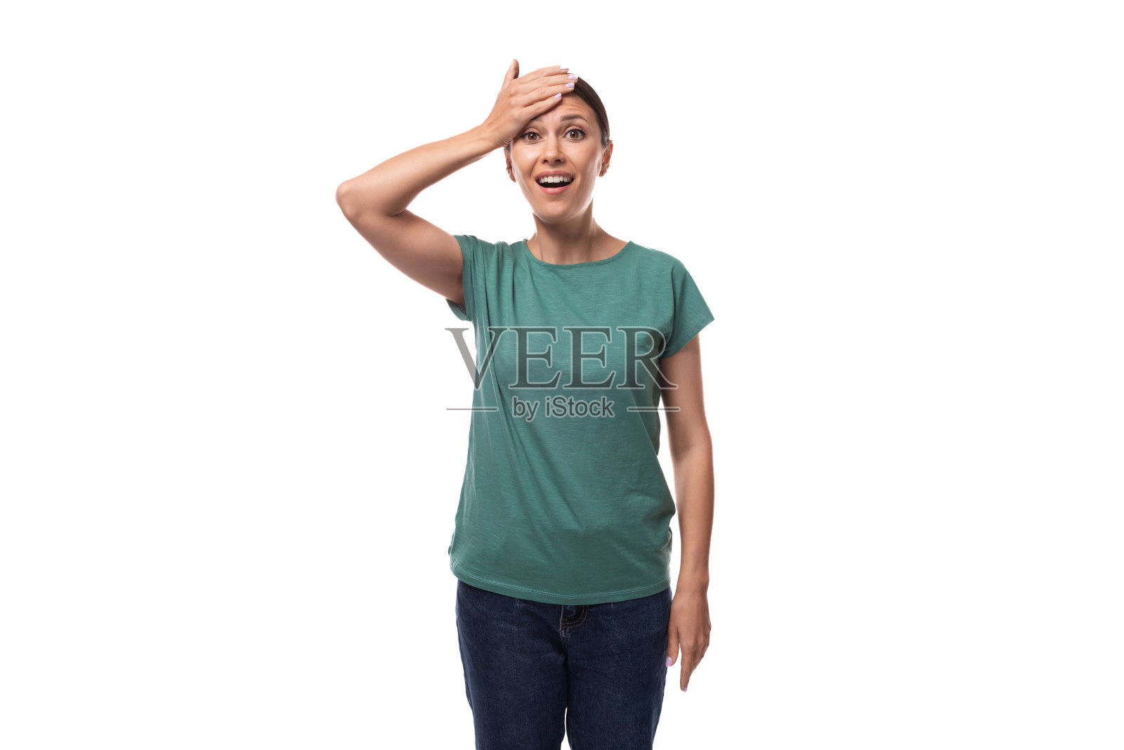 一位30岁的苗条黑发女人微笑着，头发整齐，穿着一件绿色的基本款t恤和牛仔裤照片摄影图片