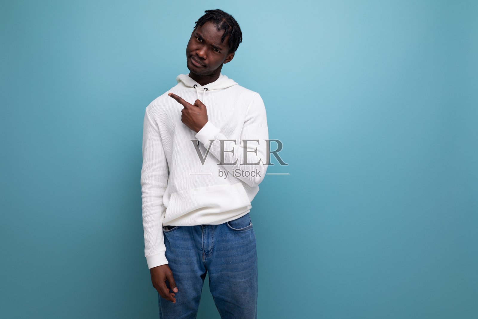 穿着休闲风格的非洲年轻黑发男子用手指向一边照片摄影图片