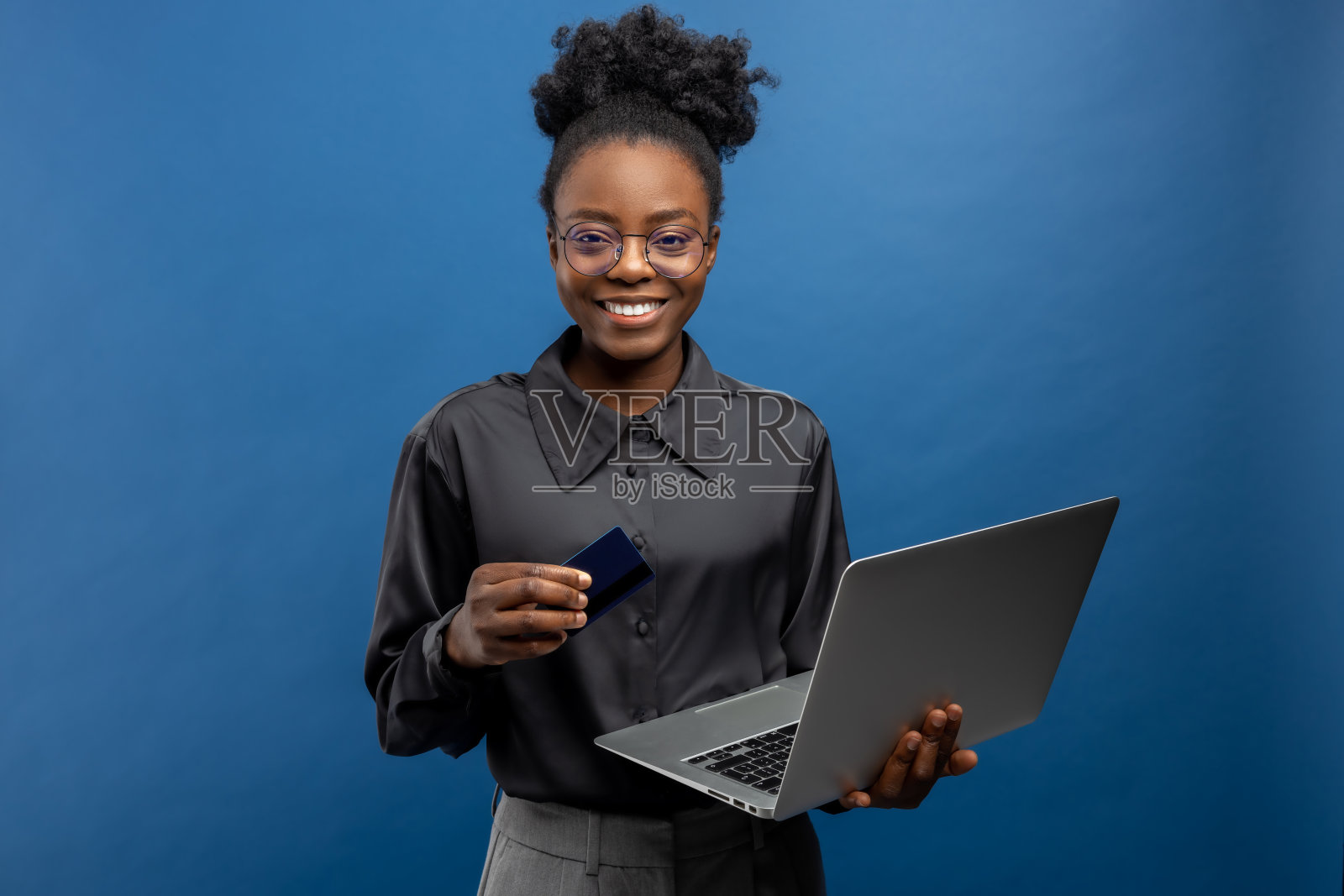 手里拿着信用卡和笔记本电脑的非裔美国女商人照片摄影图片