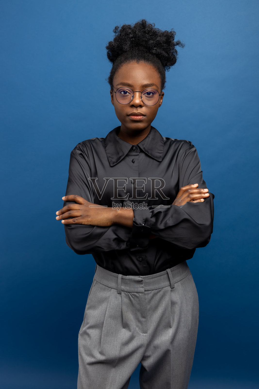 深色皮肤的年轻女子穿着黑色丝绸衬衫，看起来很自信照片摄影图片