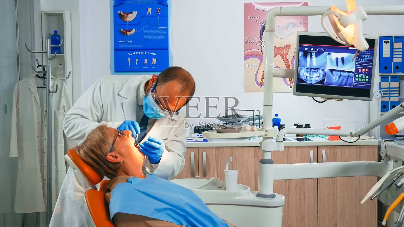 口腔外科医生用镜子检查新的牙冠照片摄影图片