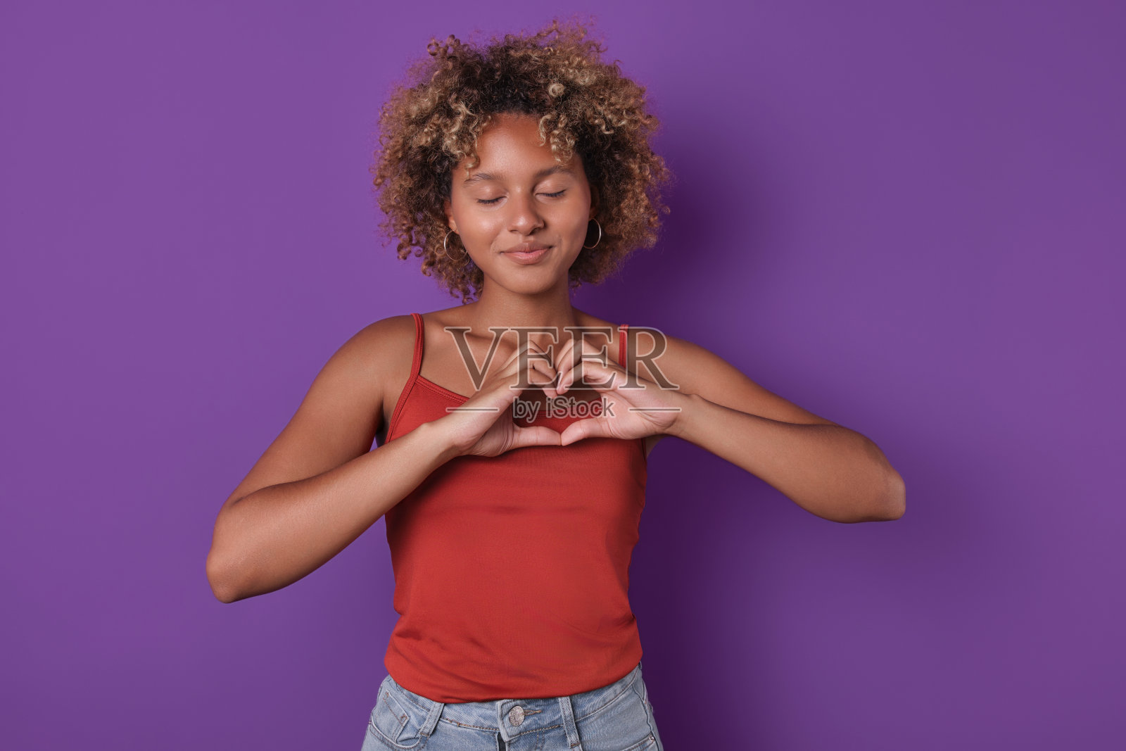 年轻浪漫可爱的非洲裔美国女人用手指做心形照片摄影图片