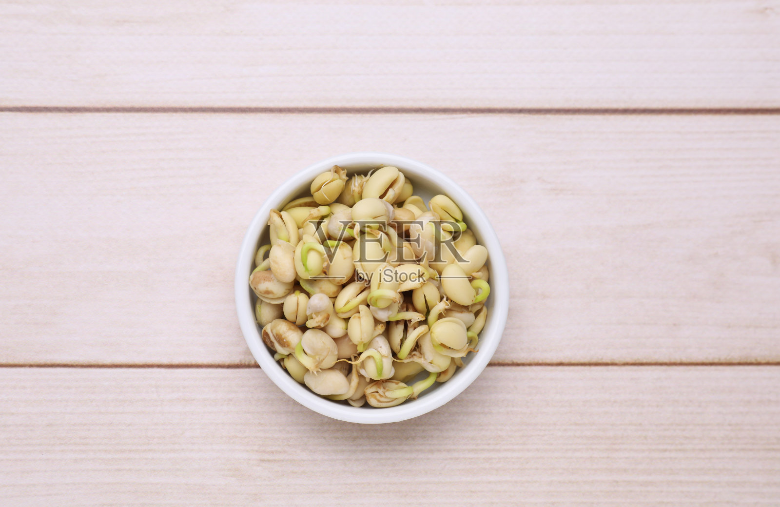 白色木桌上的碗里有发芽的芸豆，俯视图照片摄影图片