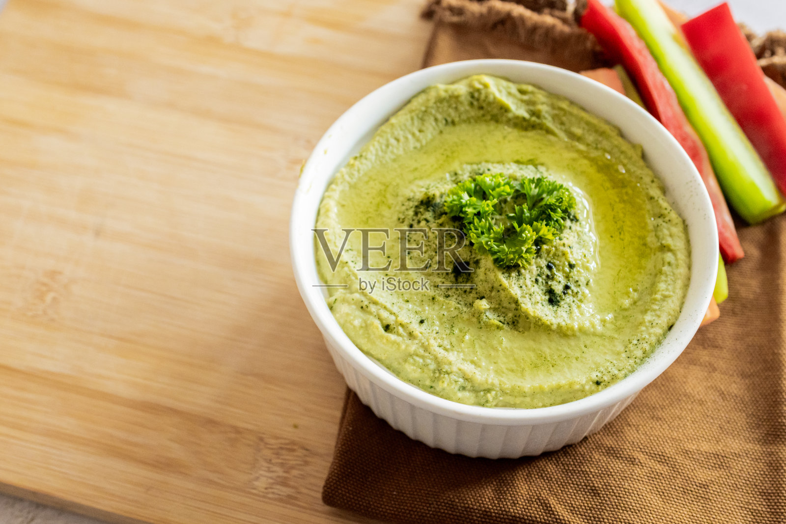 健康的自制奶油鹰嘴豆泥，上面有橄榄油和欧芹。用新鲜蔬菜装饰的美味素食。照片摄影图片