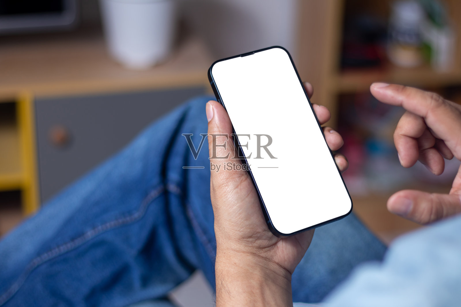 一个男人坐在咖啡店里玩智能手机放松的特写。白屏智能手机照片摄影图片