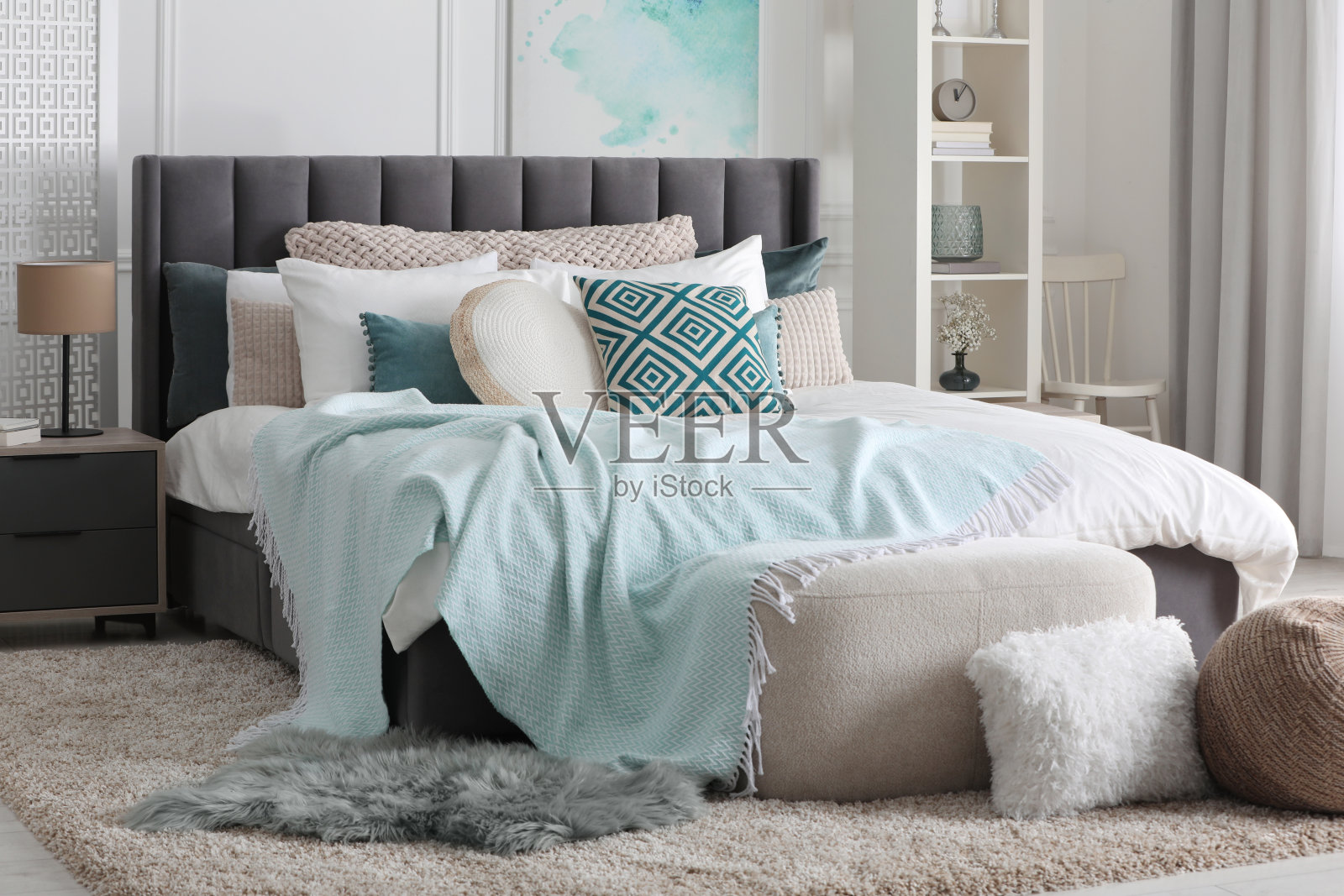 时尚的光线卧室内部与大舒适的床，搁架单元和床头柜照片摄影图片