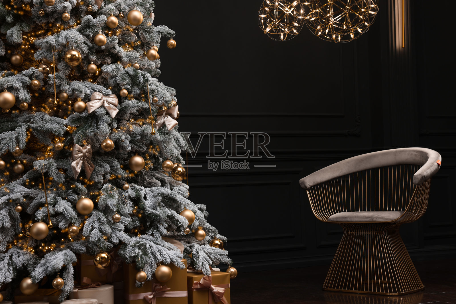 美丽的装饰圣诞树，椅子和节日装饰在黑暗的房间。室内设计照片摄影图片
