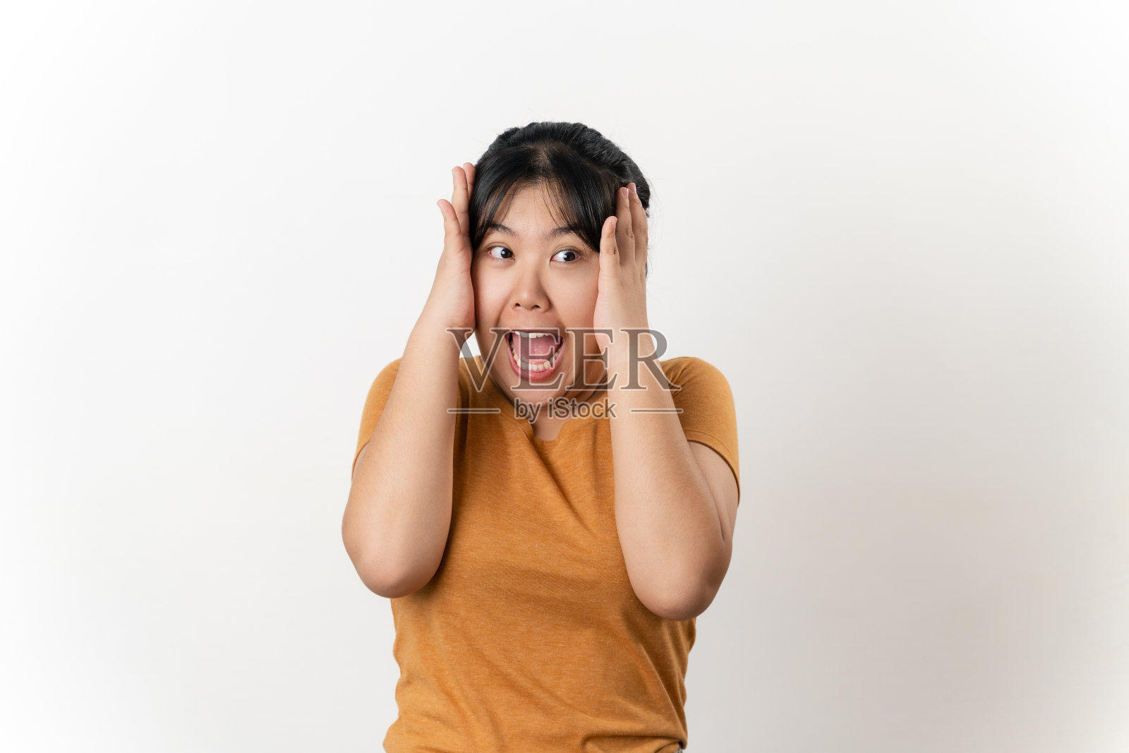 美丽的亚洲年轻女子站在白色背景上，脸上带着惊讶和震惊的表情。照片摄影图片