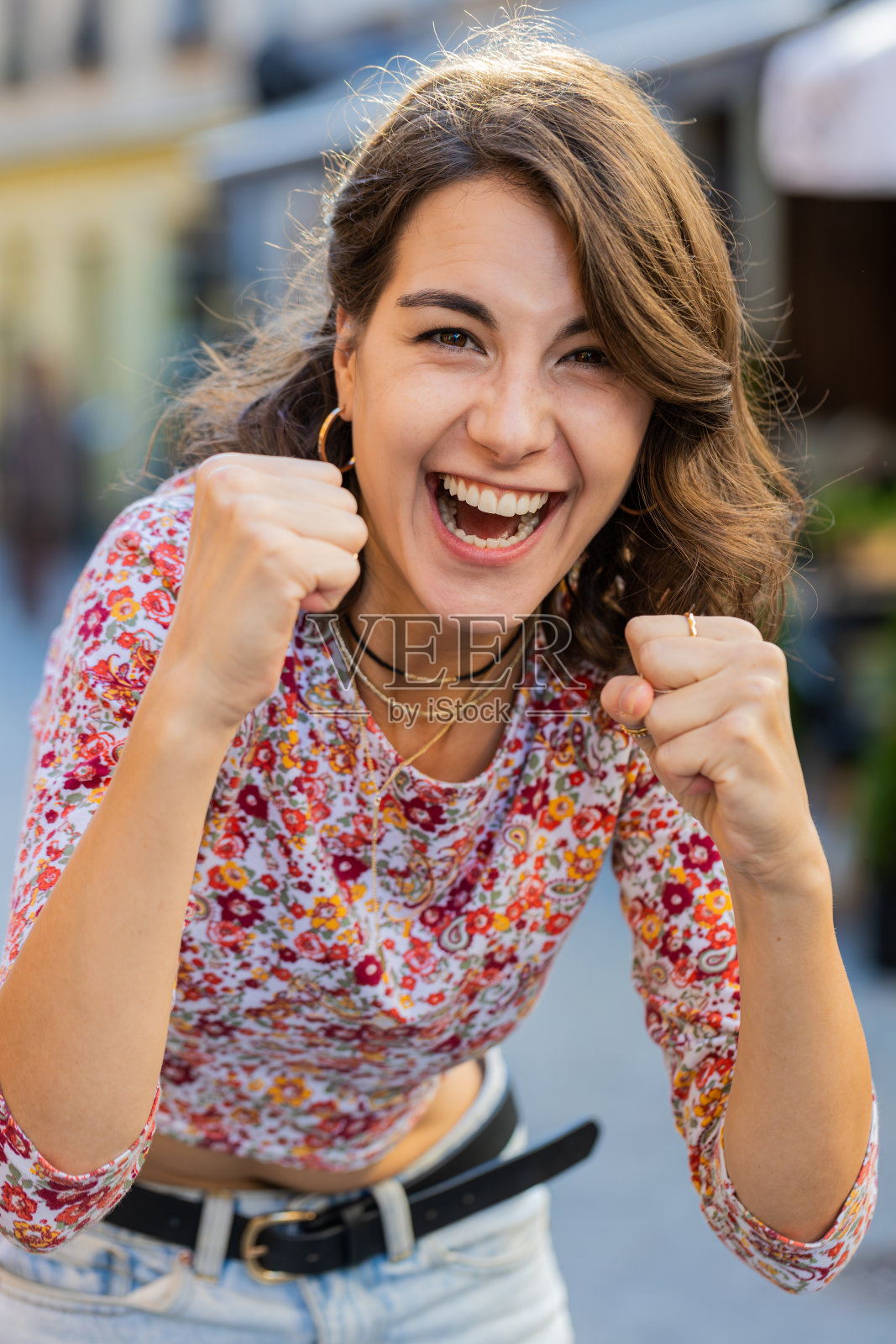 在城市的街道上，年轻的妇女呼喊着，庆祝胜利，赢得目标，取得胜利的好消息照片摄影图片