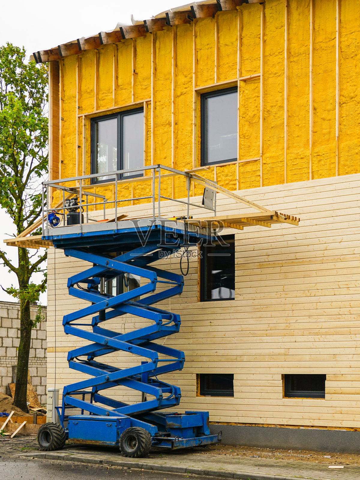 外立面喷涂保温泡沫后，用木板进行外立面覆层施工照片摄影图片