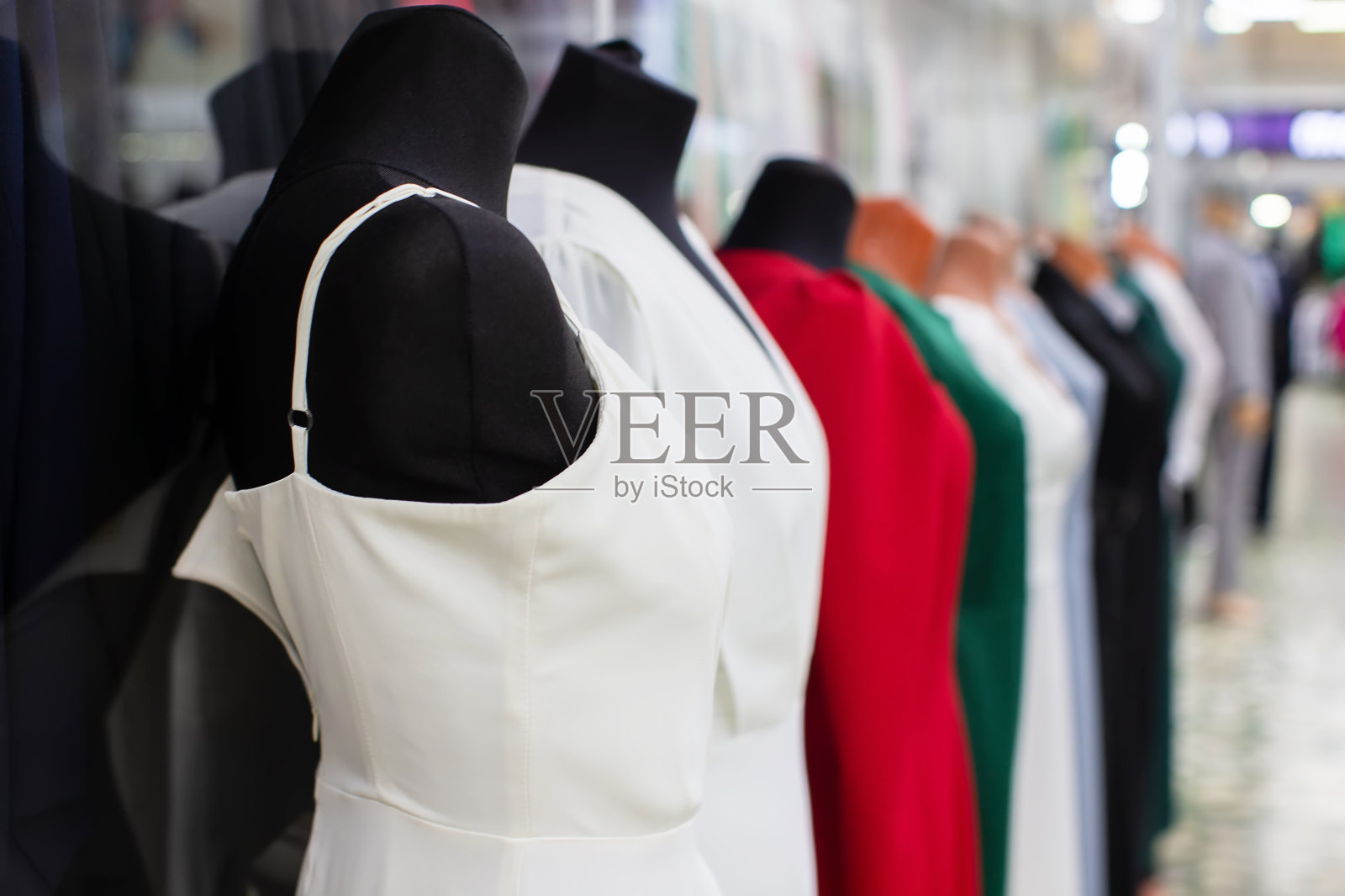 待售的黑色人体模型上的女装。照片摄影图片