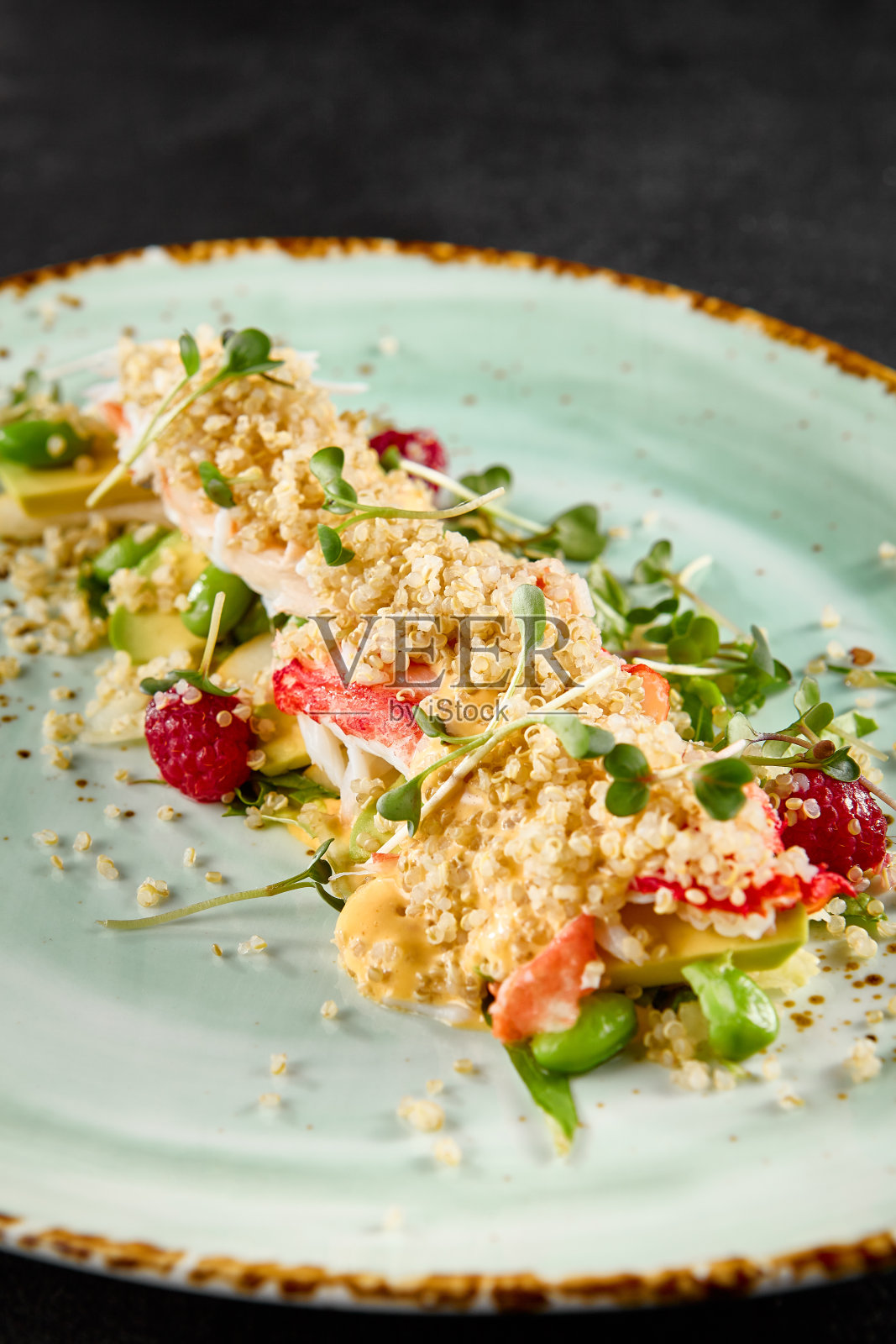 点缀着绿松石的盘子里有牛油果、蟹和藜麦沙拉照片摄影图片