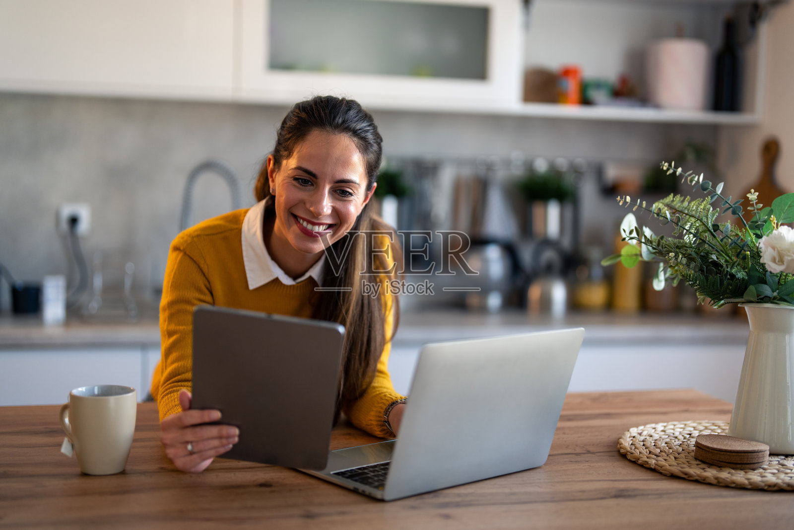 自信的女商人，穿着便装，用着平板电脑和笔记本电脑，开着视频电话会议照片摄影图片